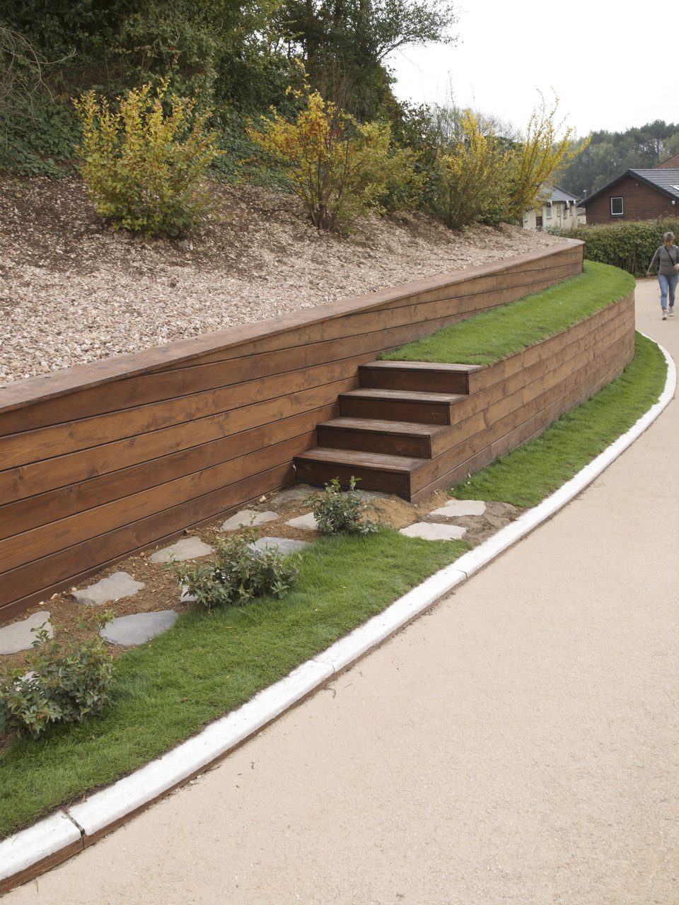 Sleeper retaining wall and steps built into a graded bank with new turf and shrub planting